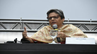 Foto da palestrante Amita Dhanda falando ao microfone.