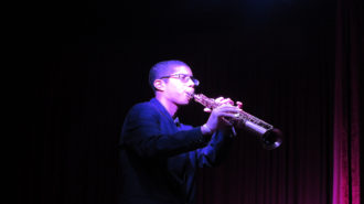 Foto de um adolescente tocando saxofone.