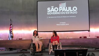 Foto da Célia Leão (Secretária de Estado dos Direitos da Pessoa com Deficiência de São Paulo) e da Izabelle Palma (Gestora do Programa Moda Inclusiva) no palco do auditório da Secretaria.